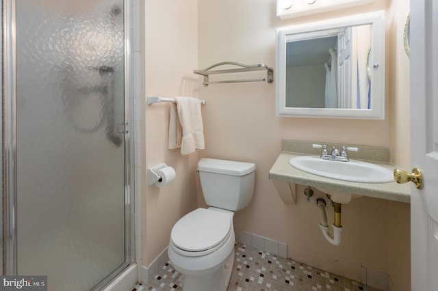 bathroom featuring tile patterned flooring, sink, a shower with shower door, and toilet