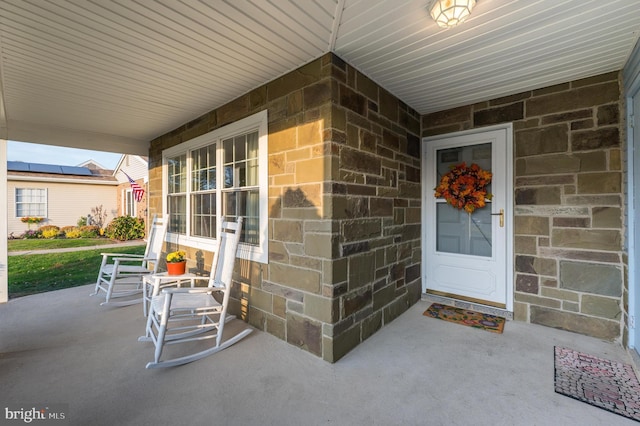 view of exterior entry featuring covered porch