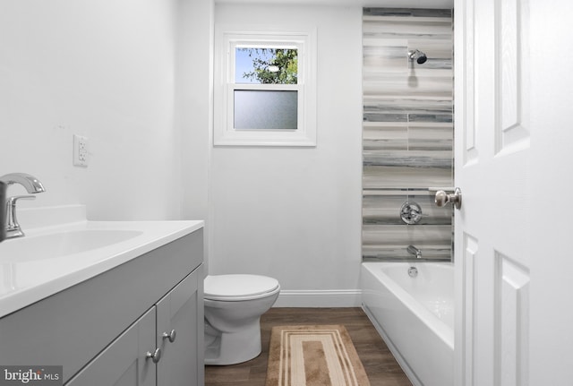 full bathroom featuring vanity, hardwood / wood-style floors, toilet, and washtub / shower combination