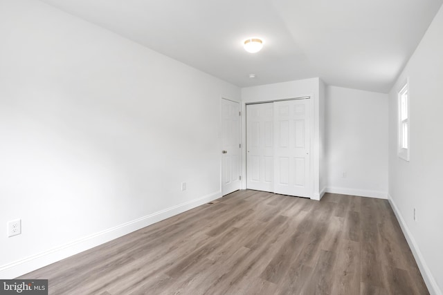 unfurnished bedroom with hardwood / wood-style flooring and a closet