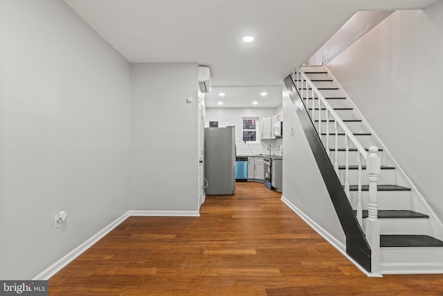 interior space with wood-type flooring and an AC wall unit