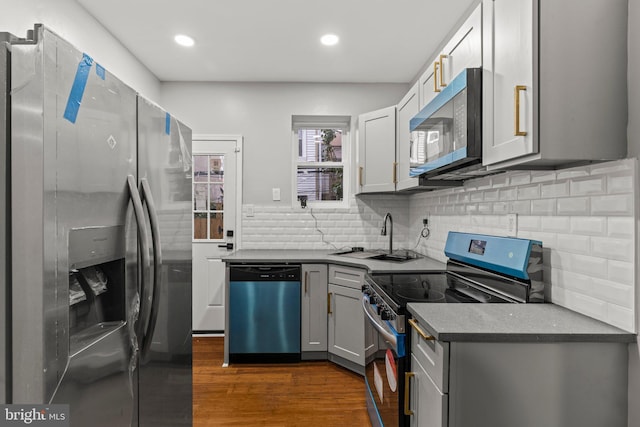 kitchen featuring gray cabinets, appliances with stainless steel finishes, tasteful backsplash, sink, and dark hardwood / wood-style flooring