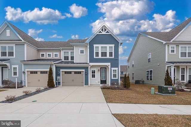 multi unit property featuring a garage, driveway, a standing seam roof, and central air condition unit