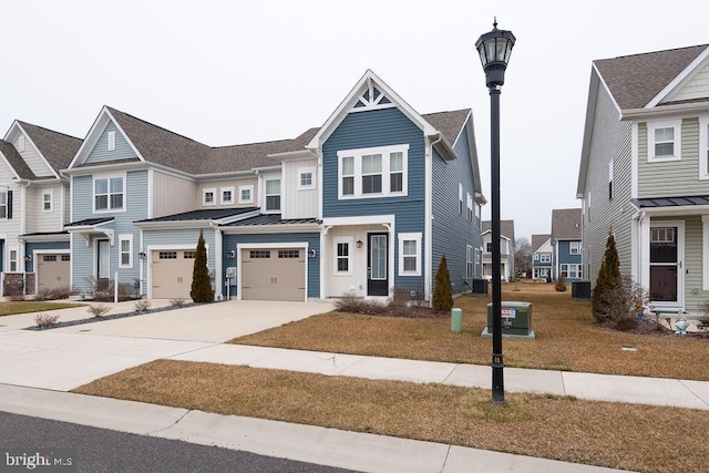 view of property featuring driveway, a residential view, metal roof, an attached garage, and a standing seam roof