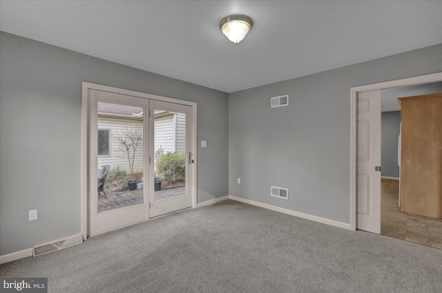 spare room featuring baseboards, visible vents, and light colored carpet