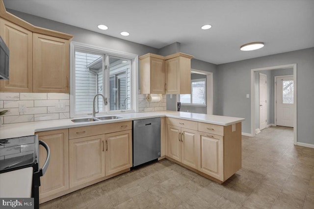 kitchen featuring light countertops, black range with electric stovetop, a sink, dishwasher, and a peninsula