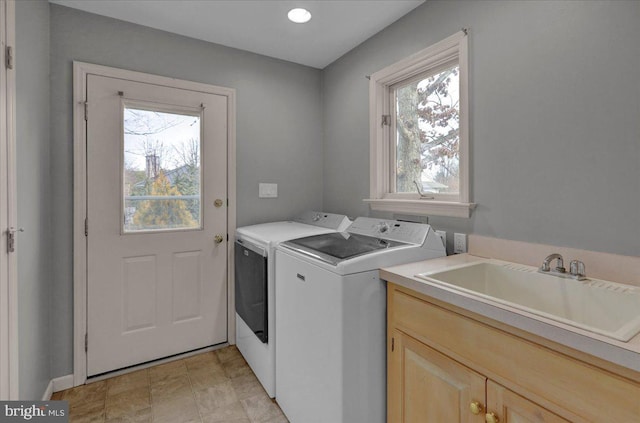 washroom with independent washer and dryer, a sink, and cabinet space