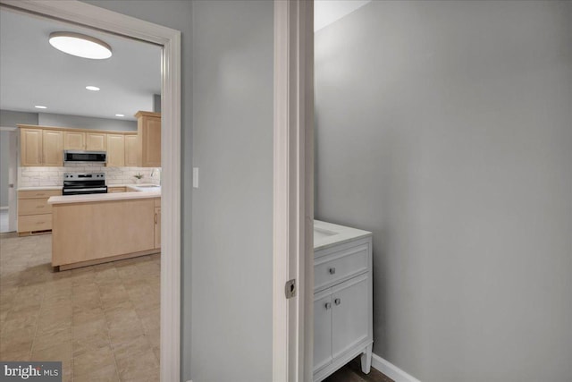 bathroom with baseboards, decorative backsplash, a sink, and recessed lighting