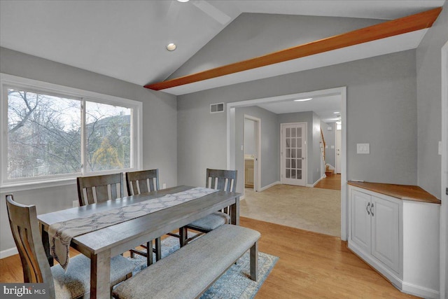 dining space featuring lofted ceiling, light wood-type flooring, visible vents, and baseboards