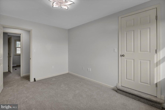 unfurnished bedroom with baseboards and light colored carpet