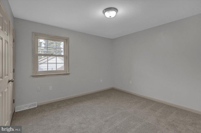 carpeted empty room with visible vents and baseboards