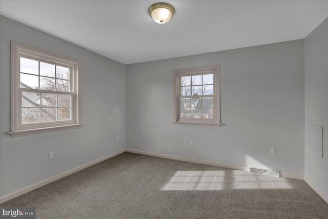 spare room with baseboards, visible vents, and carpet flooring