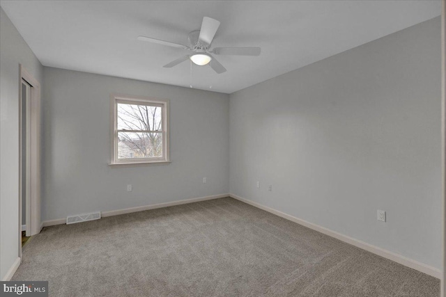 unfurnished room with light carpet, visible vents, and baseboards