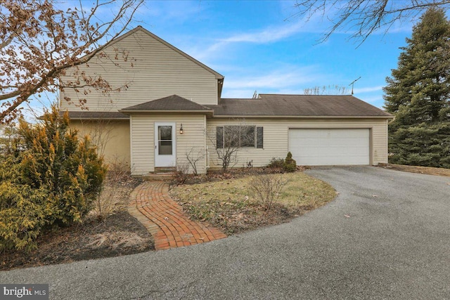 view of front of home featuring driveway, an attached garage, and entry steps