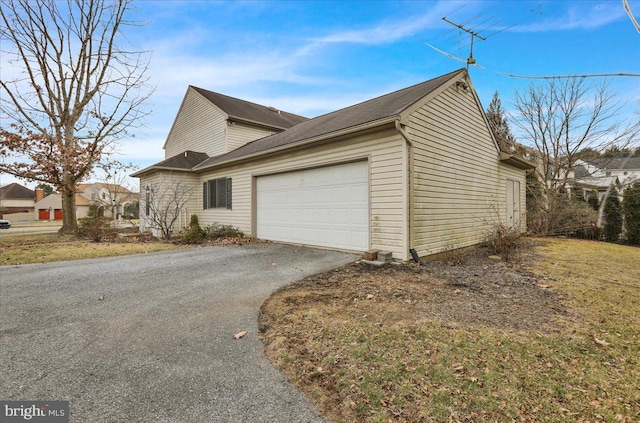 view of property exterior with aphalt driveway and an attached garage