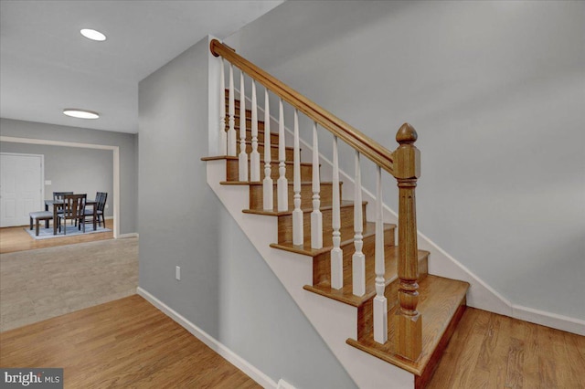 stairway with recessed lighting, baseboards, and wood finished floors