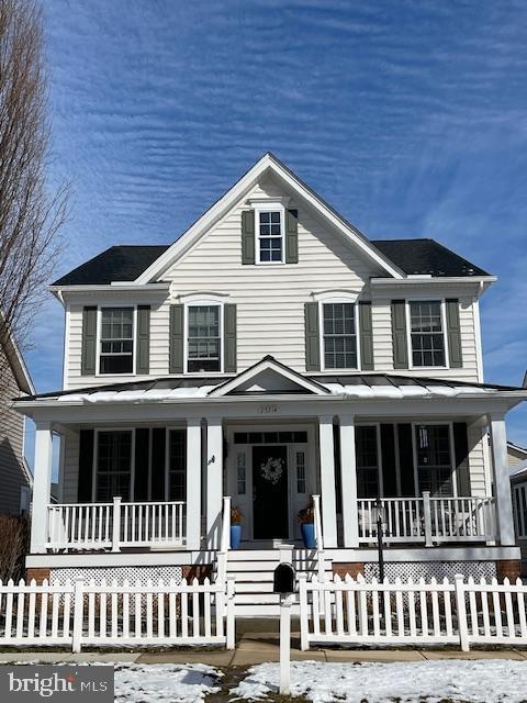 view of front of home featuring covered porch and a fenced front yard