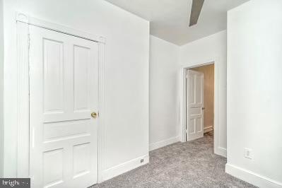 carpeted empty room featuring baseboards