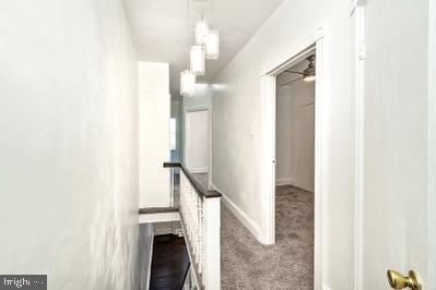 hallway with baseboards and carpet floors