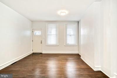 foyer entrance with baseboards and dark wood-style flooring