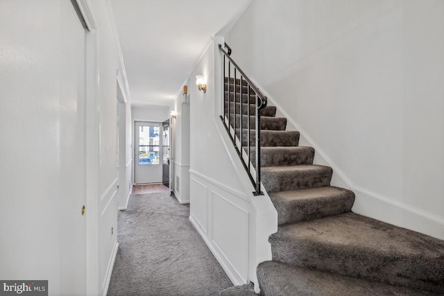 stairway with carpet flooring and crown molding