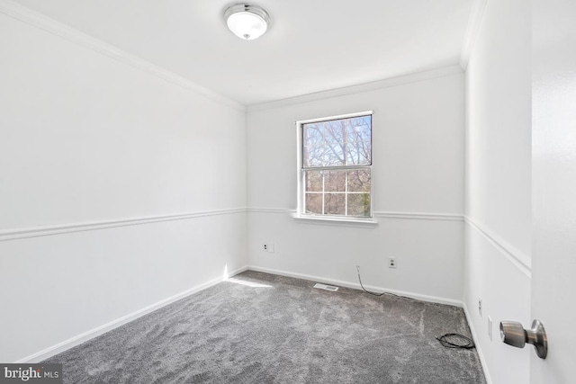 carpeted spare room with visible vents, baseboards, and ornamental molding