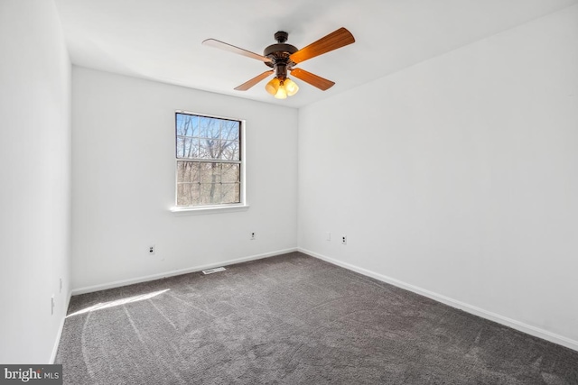 unfurnished room featuring visible vents, baseboards, dark colored carpet, and ceiling fan