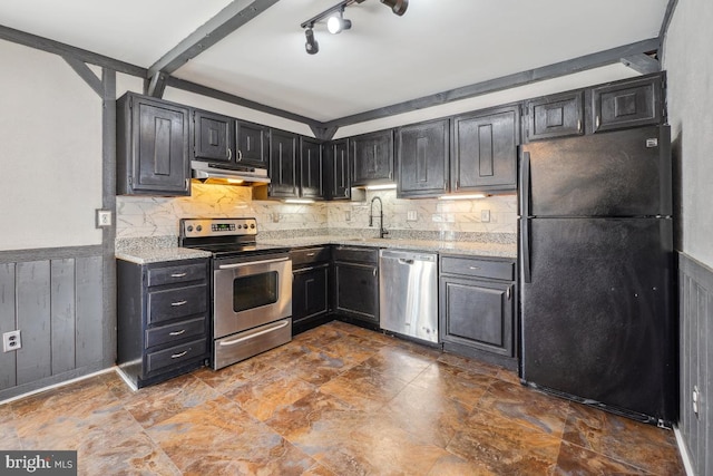 kitchen with decorative backsplash, a wainscoted wall, under cabinet range hood, and stainless steel appliances