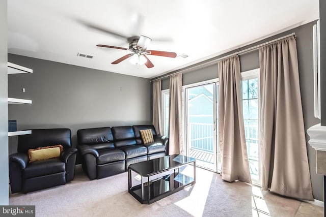 living area featuring visible vents and a ceiling fan