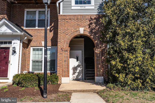 property entrance featuring brick siding