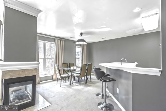 dining room with a high end fireplace, visible vents, and carpet floors