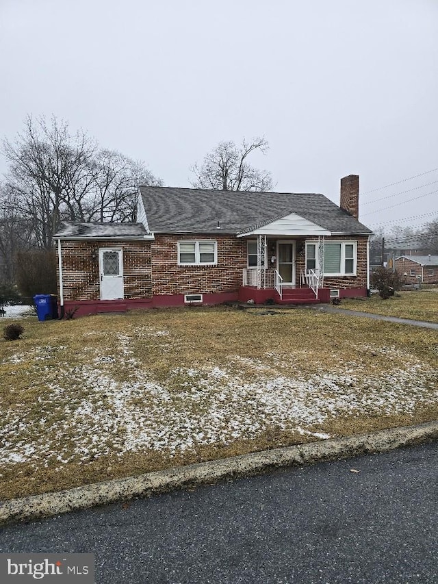 single story home featuring a chimney and brick siding