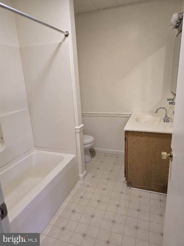 bathroom with toilet, bathing tub / shower combination, vanity, and tile patterned floors