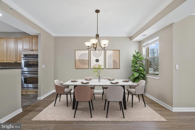 dining space with dark wood-type flooring, crown molding, baseboards, and an inviting chandelier