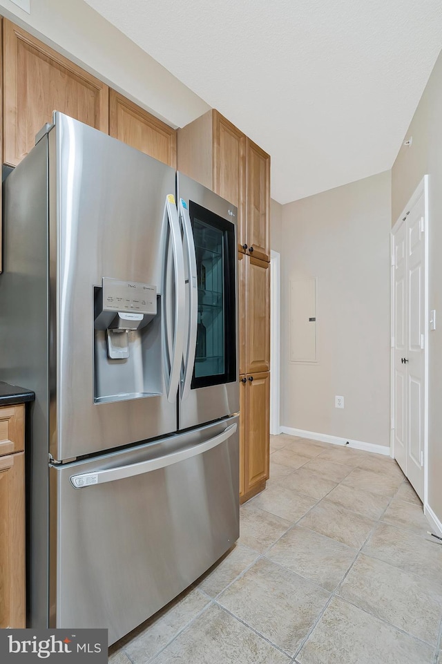 kitchen featuring stainless steel fridge and baseboards