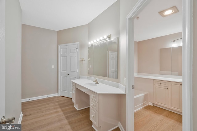 bathroom with vanity, baseboards, and wood finished floors