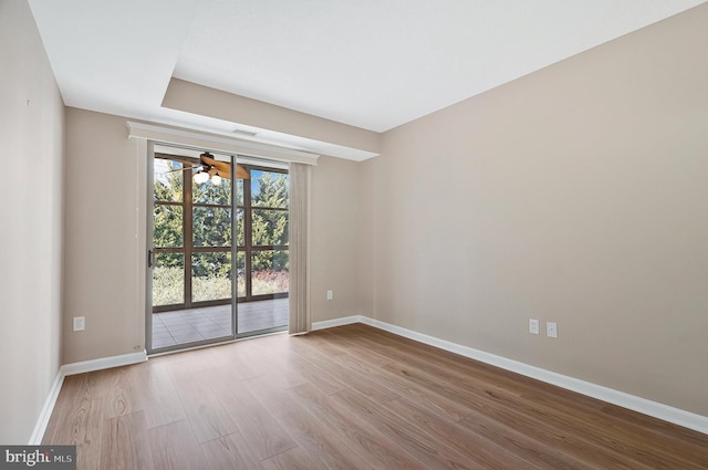 unfurnished room featuring a ceiling fan, baseboards, and light wood finished floors