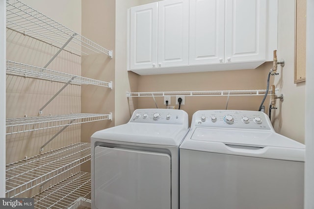 laundry area with washing machine and clothes dryer and cabinet space