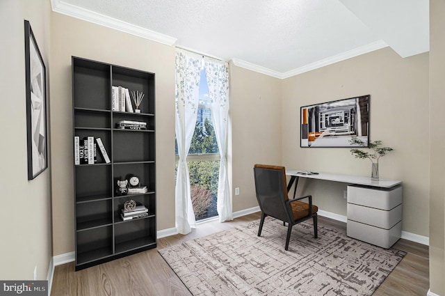 office space featuring light wood-type flooring, baseboards, and crown molding