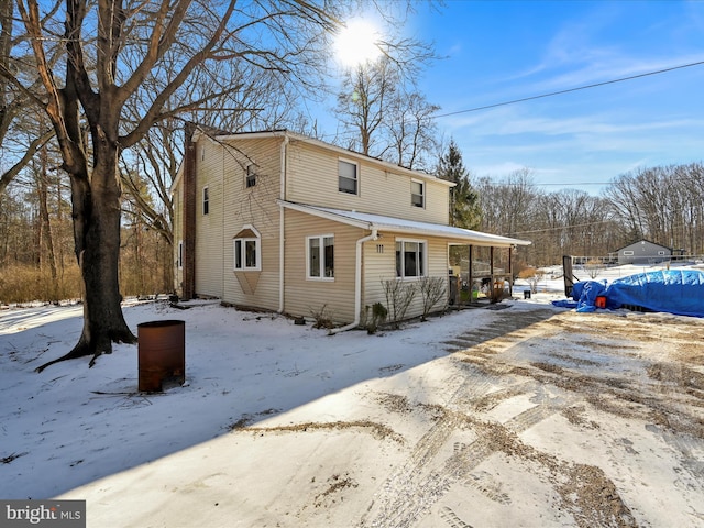 view of snow covered rear of property