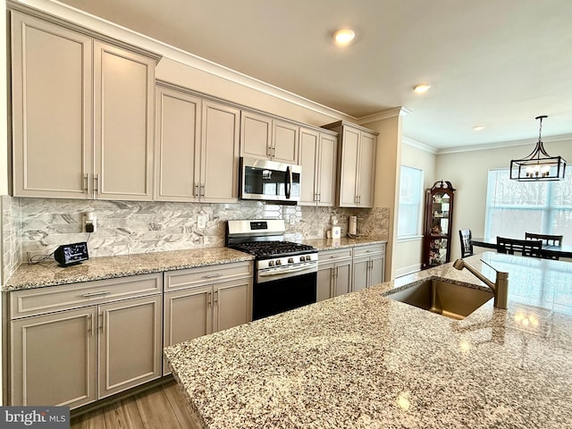 kitchen featuring light stone counters, stainless steel appliances, sink, and tasteful backsplash