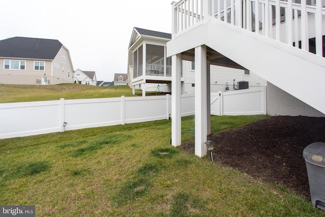 view of yard with central AC unit and a sunroom