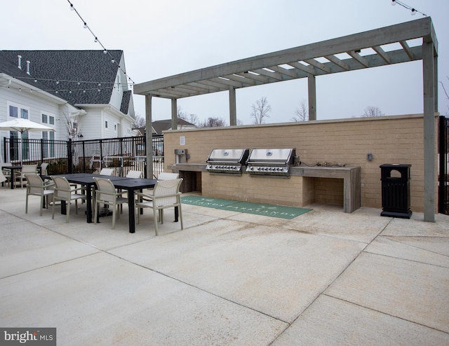 view of patio / terrace with a grill, a pergola, and an outdoor kitchen