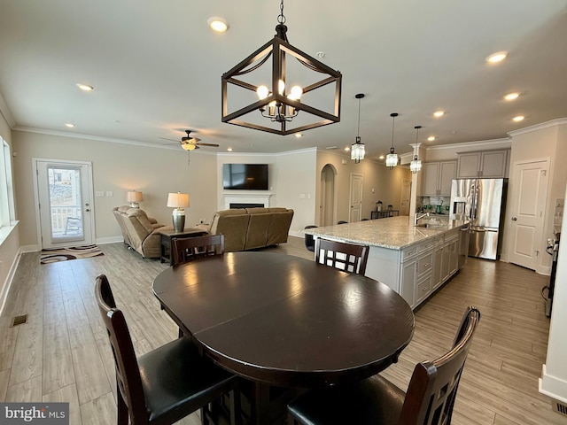 dining space featuring ornamental molding and light hardwood / wood-style flooring