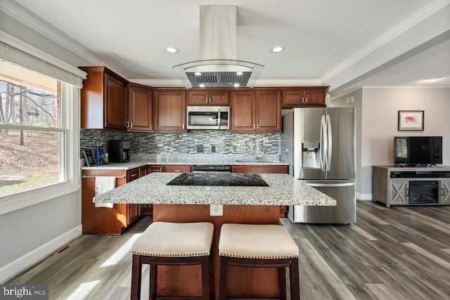 kitchen with island exhaust hood, a center island, stainless steel appliances, crown molding, and decorative backsplash