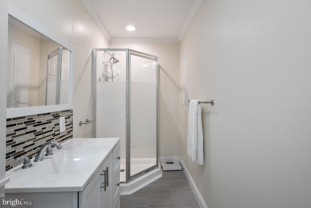 full bath featuring decorative backsplash, crown molding, vanity, and a shower stall