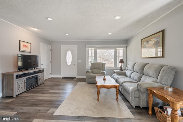 living area with recessed lighting, a textured ceiling, baseboards, and dark wood-style flooring