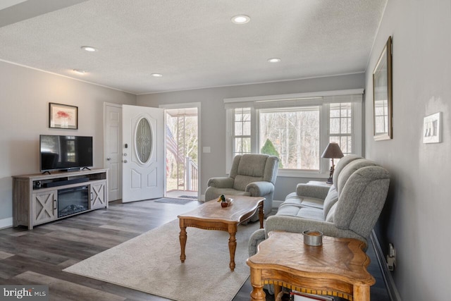 living room with dark wood finished floors, plenty of natural light, recessed lighting, and a textured ceiling