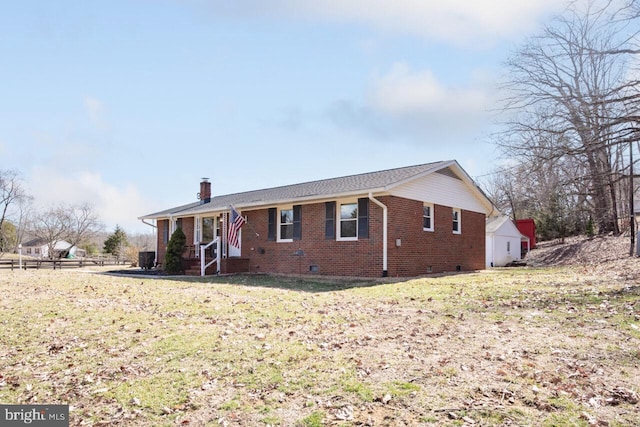 view of front of home with a front yard, fence, a chimney, crawl space, and brick siding