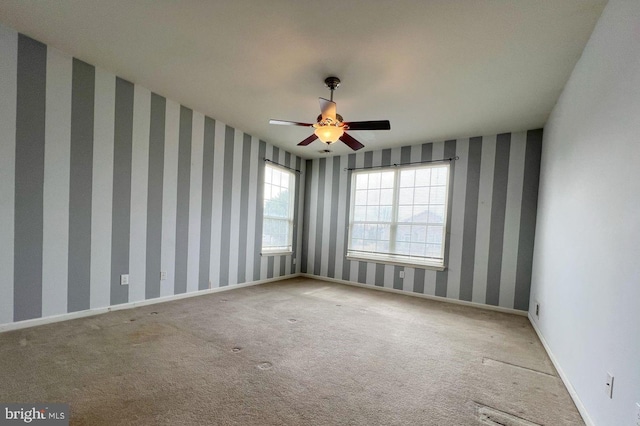 carpeted spare room featuring ceiling fan